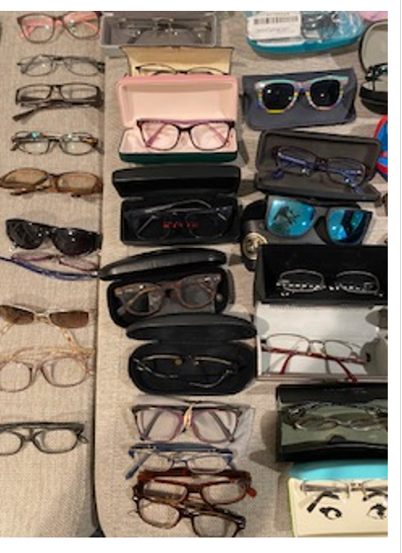 Hundreds of donated eyeglasses and cases laid out in rows